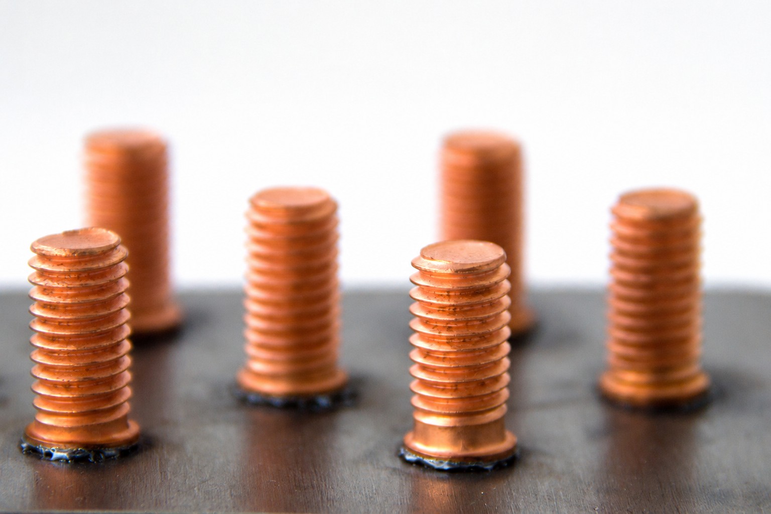 Copper-plated CD studs welded on steel sheet, close-up