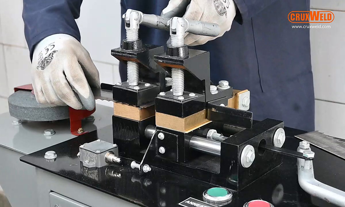 Bandsaw blade clamped in the dual copper jaws of the UltraFlex 520 bandsaw blade butt welder